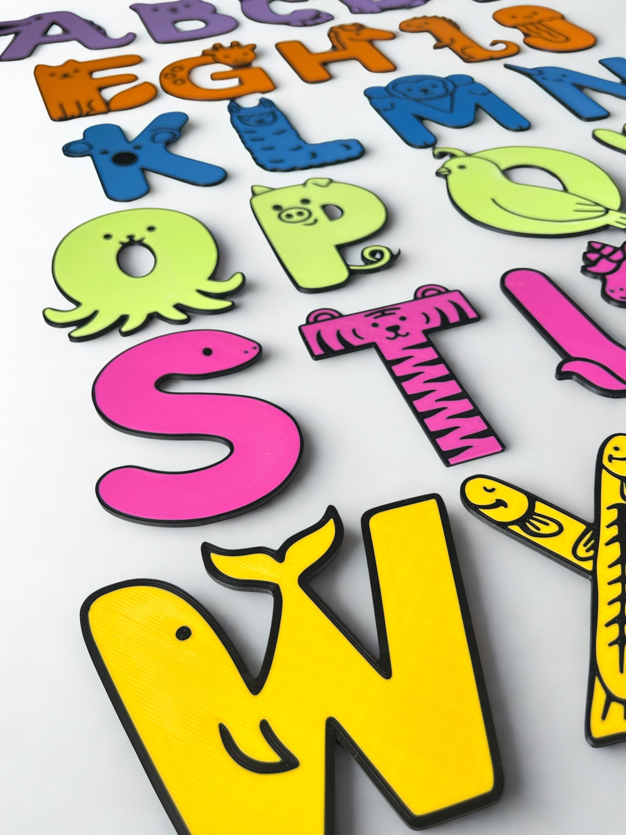 Side view of 3D printed animal alphabet letters A to Z on a white background