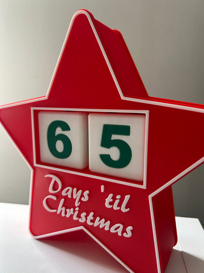 Red star-shaped Christmas countdown calendar with '65 days 'til Christmas' text.