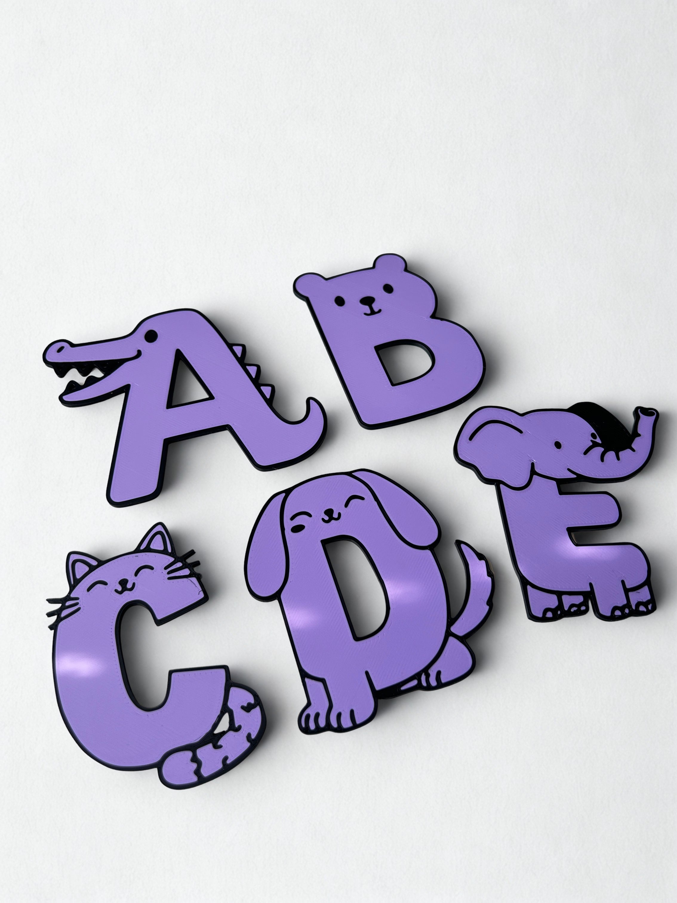 3D printed purple animal alphabet letters A to E on a white background
