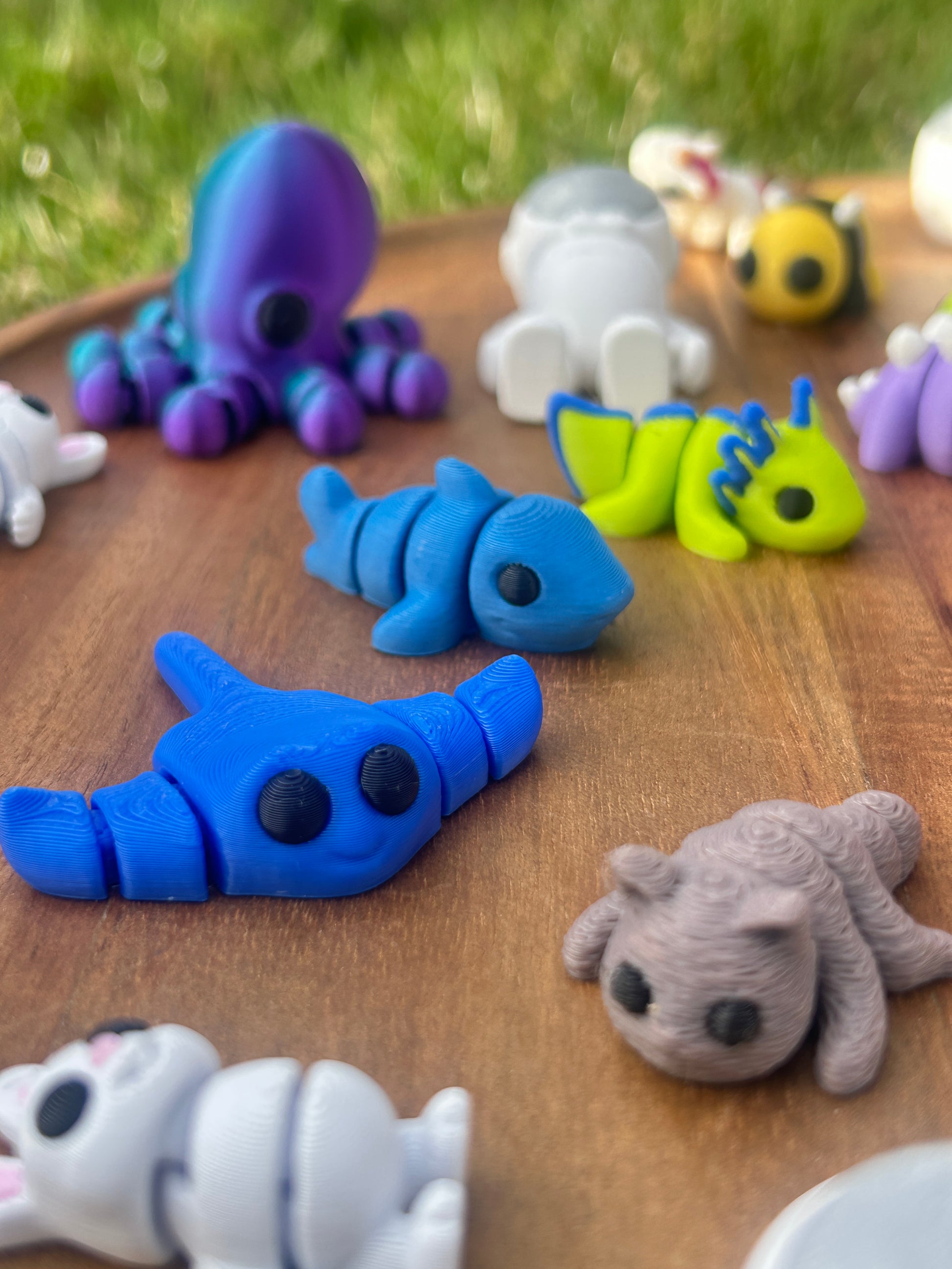 Close up shot of 3D printed Mini Critters including a blue Sting-ray, Octopus, and White Bunny.