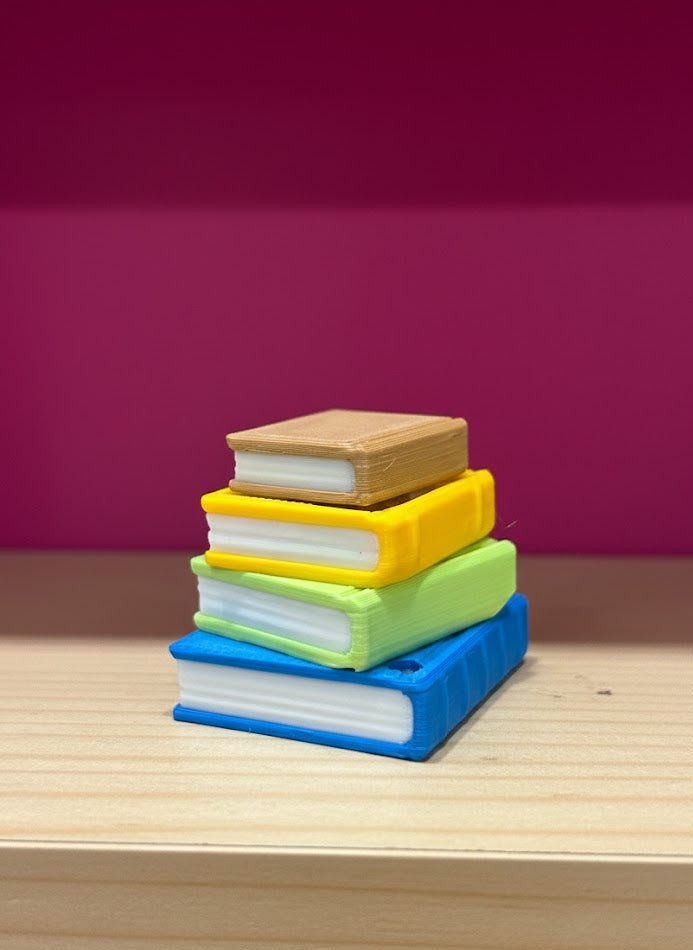 Stack of colorful books on a wooden surface with a purple background
