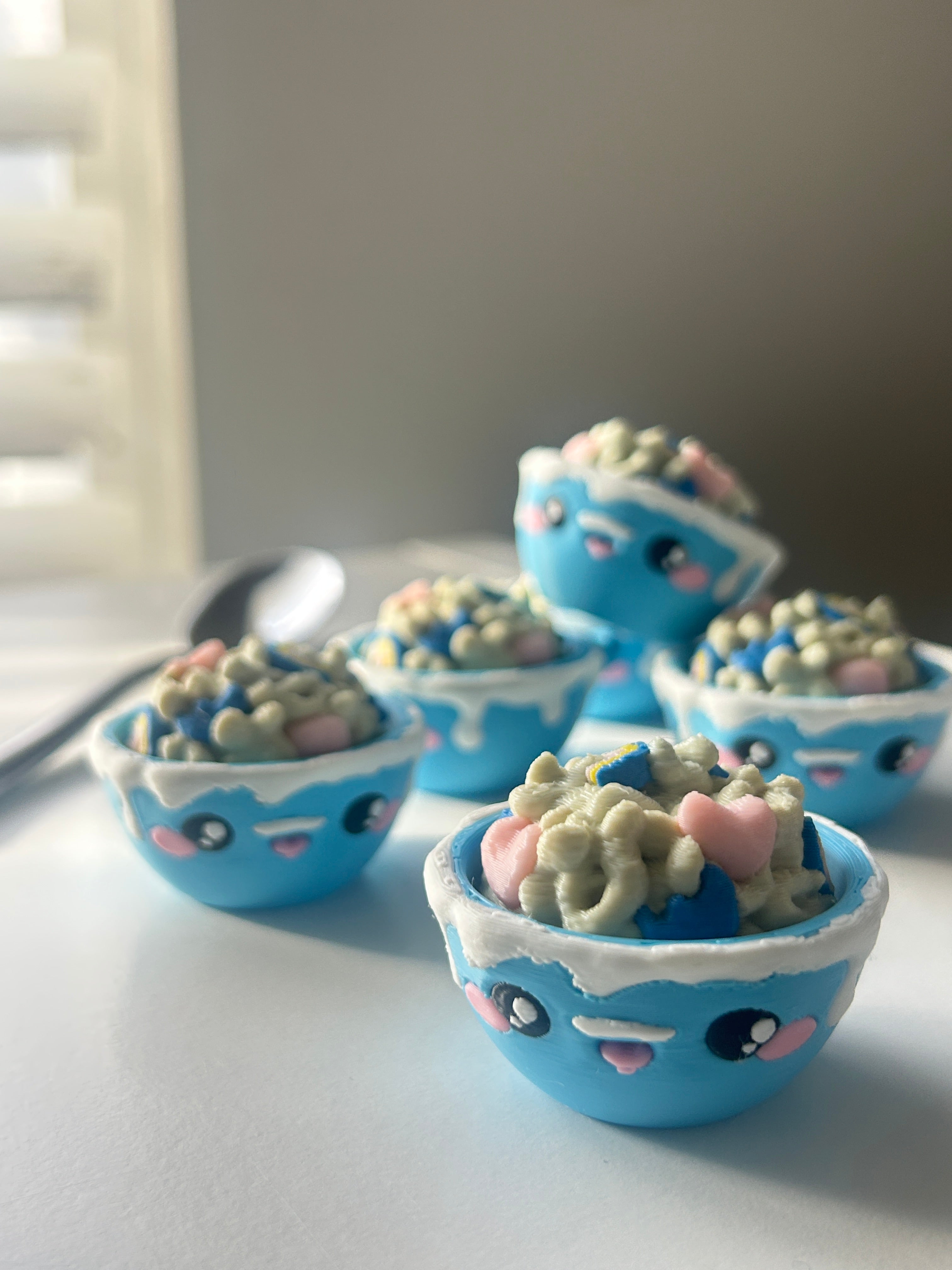Cute blue bowls of Lucky Charms cereal with Kawaii faces that have pink cheeks.