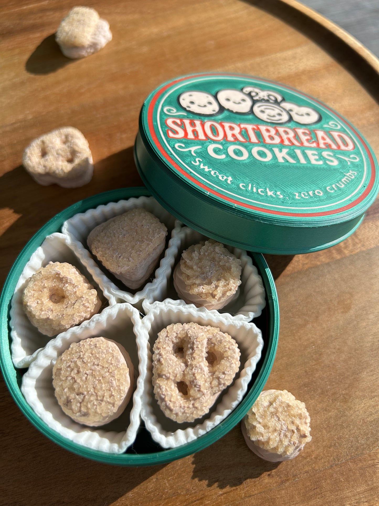 An open tin of 3D printed shortbread cookies on a wooden surface.