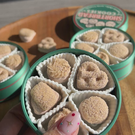 Woman's hand fidgeting with shortbread cookies tin fidget clicker.