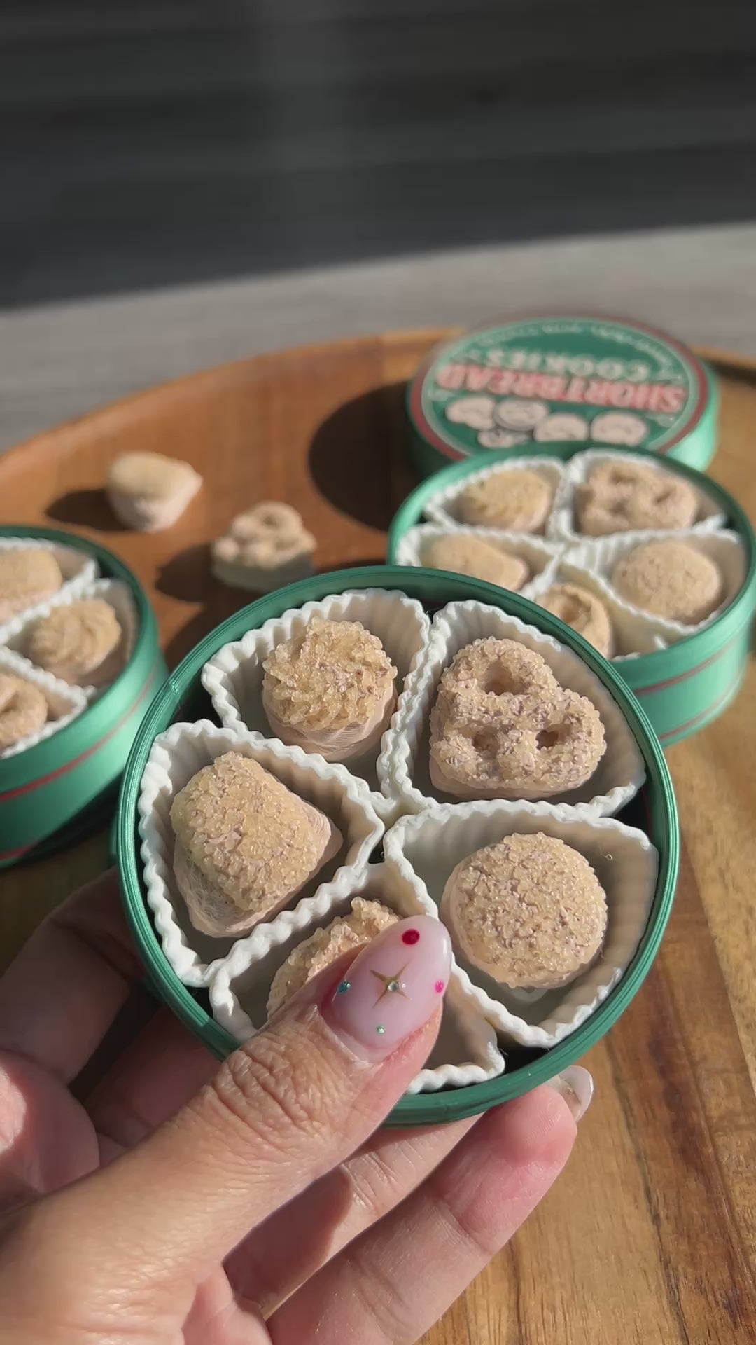 Woman's hand fidgeting with shortbread cookies tin fidget clicker.