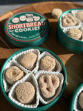 Open containers of shortbread cookies on a wooden surface
