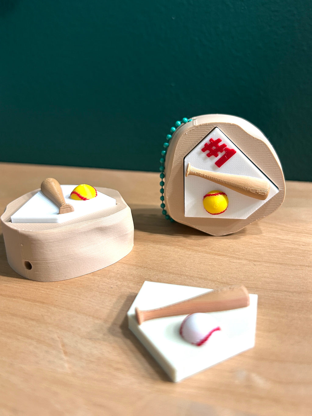 Three 3D printed softball and baseball fidget clicker keychains.